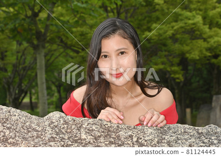 Woman peeking from the top of the rock Woman peeking from the top of the rock 81124445