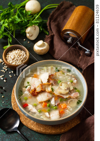 Healthy eating. Homemade hearty soup with cereals, bacon and mushrooms on a dark stone background. 81124639