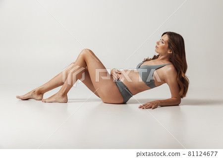 Portrait of beautiful pregnant woman in lingerie isolated over grey studio background. Natural beauty, happy motherhood, femininity concept. Portrait of beautiful pregnant woman in lingerie isolated over grey studio background. Natural beauty, happy motherhood, femininity concept. 81124677