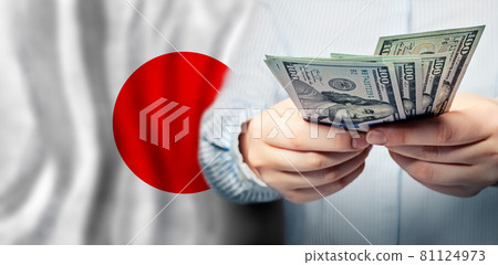 American dollars in hands on flag of Japan American dollars in hands on flag of Japan 81124973