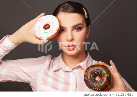 Hungry woman holding donuts on black background portrait, diet concept 81125425