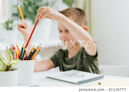 Distance learning online education. Caucasian smile kid boy studying at home with book, draw in notepad and doing school homework. Thinking child siting at table with notebook. Back to school Distance learning online education. Caucasian smile kid boy studying at home with book, draw in notepad and doing school homework. Thinking child siting at table with notebook. Back to school 81126777