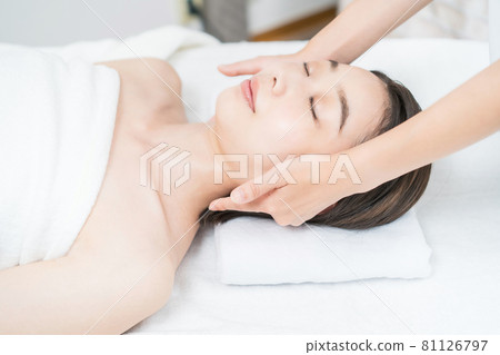 Young woman having her head massaged at the beauty salon Young woman having her head massaged at the beauty salon 81126797