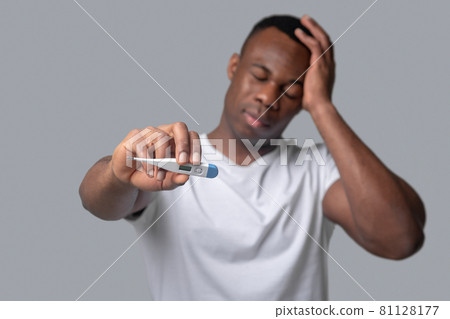 A dark-skinned man in a white tshirt feeling unwell A dark-skinned man in a white tshirt feeling unwell 81128177