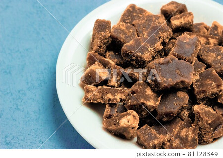 Close-up photo of brown sugar on a white plate 81128349