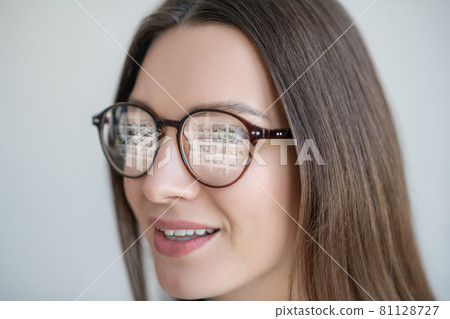 Headshot of long-haired woman in eyewear looking positive 81128727