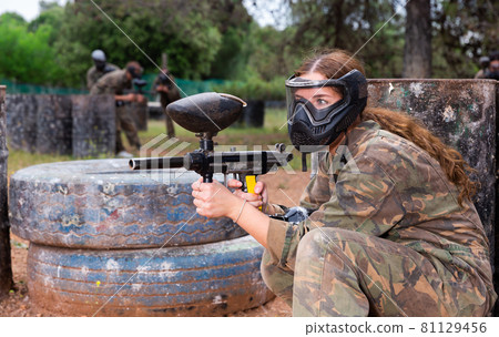 Portrait of girl in camouflage on paintball field Portrait of girl in camouflage on paintball field 81129456