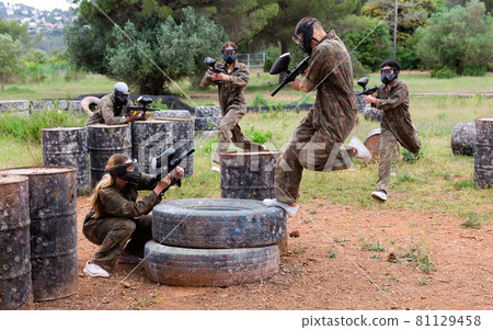 Two active opposing teams with guns playing paintball Two active opposing teams with guns playing paintball 81129458