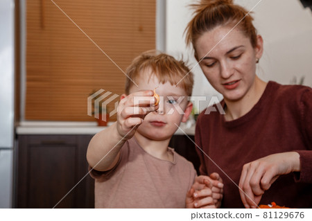 Female hands plant eco vegetable seeds. Young mother and son playing with dirt prepared for seeds. a child cares for plants, a home garden. Mother with little son cultivating plants at home. Female hands plant eco vegetable seeds. Young mother and son playing with dirt prepared for seeds. a child cares for plants, a home garden. Mother with little son cultivating plants at home. 81129676