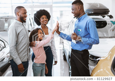 Lovely black girl high fiving friendly salesman at auto dealership 81129927