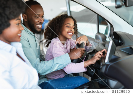Cheerful black family checking car salon before buying new automobile, sitting inside auto, going on test drive 81129930