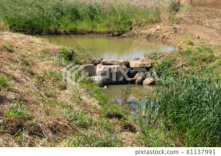 The small reservoir is blocked by the large rock for storage of the water. The small reservoir is blocked by the large rock for storage of the water. 81137991