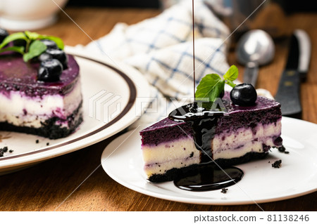 Pouring chocolate on a piece of delicious homemade blueberry cheesecake. 81138246