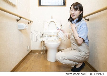 Female worker disinfecting the toilet with alcohol 81139971