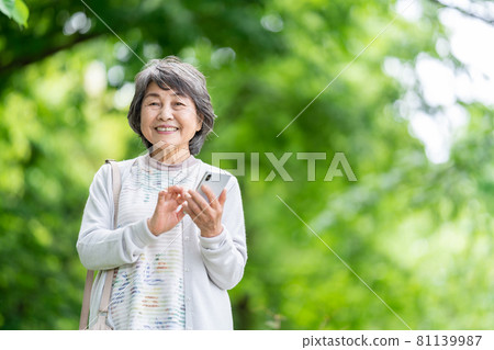 A senior woman who operates a smartphone, an old woman who touches a smartphone outdoors A senior woman who operates a smartphone, an old woman who touches a smartphone outdoors 81139987