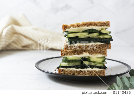 Healthy sandwich with cucumber and kale leaves. Vegan food snack, breakfast. Copy space. Healthy sandwich with cucumber and kale leaves. Vegan food snack, breakfast. Copy space. 81140426