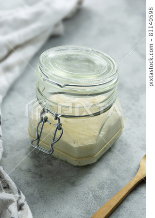 Sourdough starter in a jar, yeast-free leaven starter for healthy organic rustic bread, home baking concept 81140598