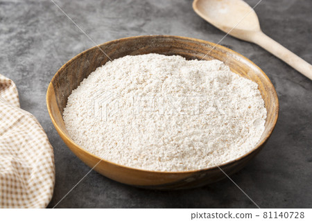 Whole grain flour in wooden bowl. Baking ingredient for pastry and bread. 81140728