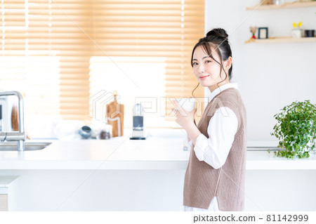 在廚房裡喝咖啡放鬆的年輕女人 81142999