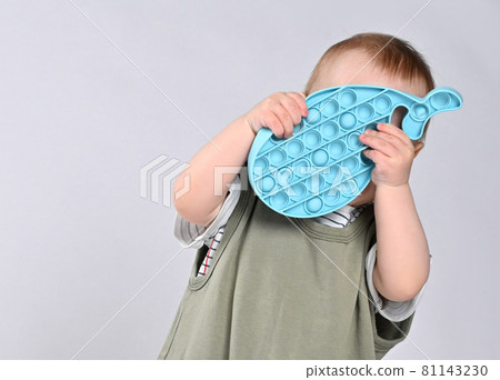 Curious little boy using toy pop it isolated on 81143230