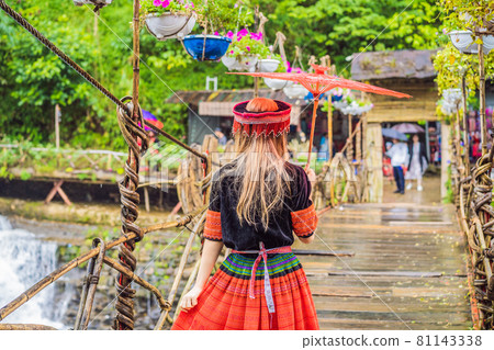 A female tourist dressed in the traditional dress of the inhabitants of the Vietnamese mountains, the Hmong. Woman in Sapa in the fog, Northwest Vietnam. Vietnam travel concept. UNESCO heritage 81143338