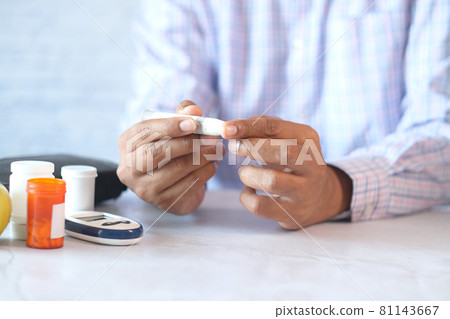 man's hand measuring blood sugar level  81143667