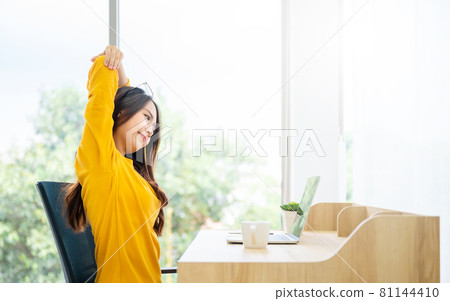 Young asian woman feeling pain in neck and shoulder after working on computer laptop for a long time 81144410