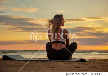 Yoga exercises during sunset by Caucasian woman. Yoga exercises during sunset by Caucasian woman. 81144435