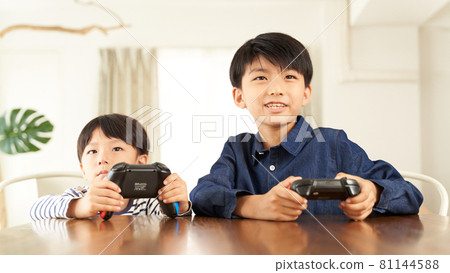 Two boys playing on a home video game console 81144588