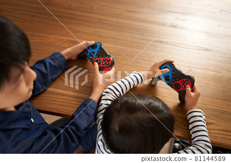 Hands of a boy with a gamepad 81144589