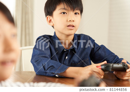 Boy playing on a home video game console 81144856