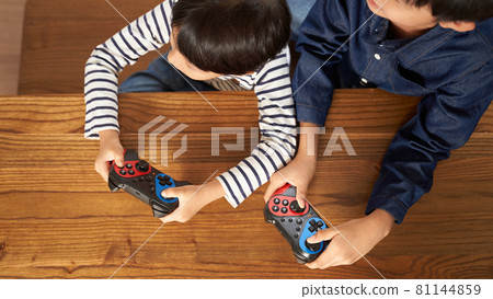 Hands of a boy with a gamepad 81144859
