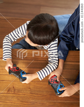 Hands of a boy with a gamepad 81144860