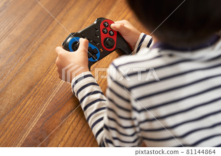 Hands of a boy with a gamepad 81144864