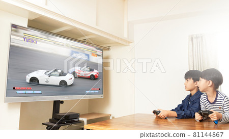 Two boys playing video games in the living room 81144867