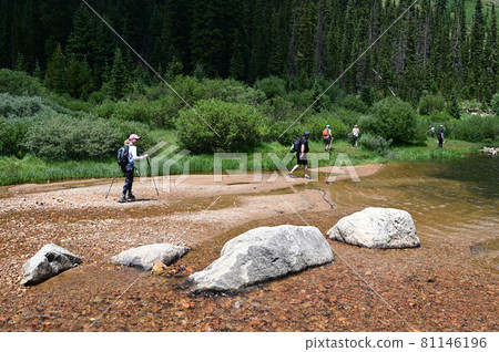 Hikers in shallow water on Hassell Lake Trail in Arapaho Nat'l Forest, Colorado. Hikers in shallow water on Hassell Lake Trail in Arapaho Nat'l Forest, Colorado. 81146196