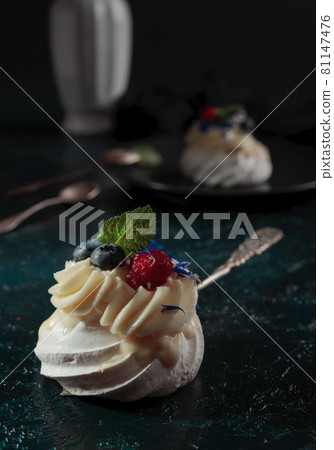Pavlova dessert with raspberry, blueberry, and mint. 81147476