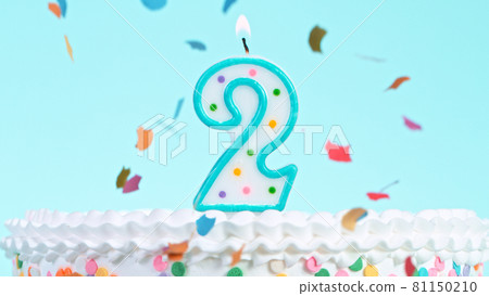 Colorful tasty birthday cake with candles shaped like the number 2. 81150210