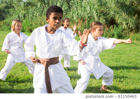Children in kimono practicing karate in summer outdoors 81150463