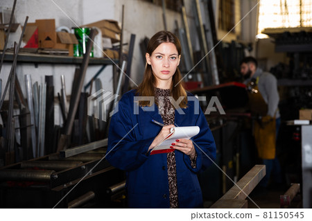 Metalworking factory workwoman noting measurement Metalworking factory workwoman noting measurement 81150545