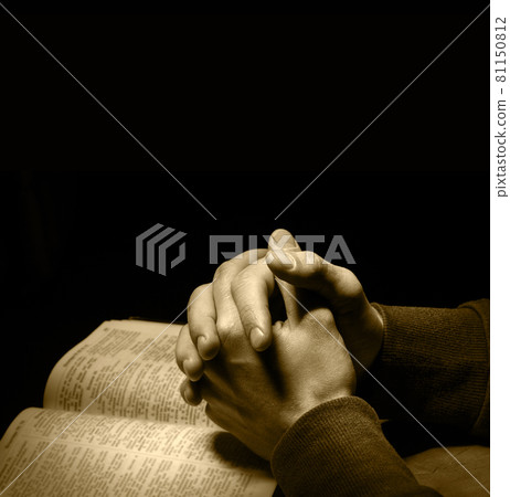 Hands folded in prayer over Scriptures Hands folded in prayer over Scriptures 81150812