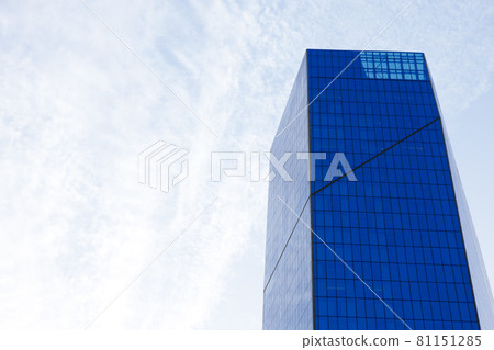 Glass skyscraper building with cloudy blue sky background Glass skyscraper building with cloudy blue sky background 81151285