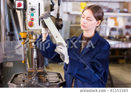Woman worker in uniform working with metal beams Woman worker in uniform working with metal beams 81151583