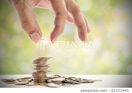 Human hand placing a coin on a pile of coins, use for for business and financial growth concepts. Human hand placing a coin on a pile of coins, use for for business and financial growth concepts. 81151945