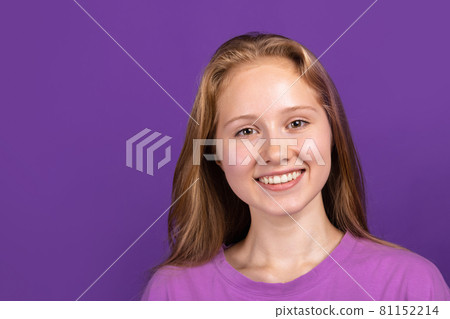 Half-length portrait of young beautiful smiling girl isolated on purple studio background. Concept of human emotions, facial expression, youth, sales, ad. Half-length portrait of young beautiful smiling girl isolated on purple studio background. Concept of human emotions, facial expression, youth, sales, ad. 81152214