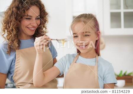 Mother and teen daughter making dough for pastry toghether in kitchen 81154229
