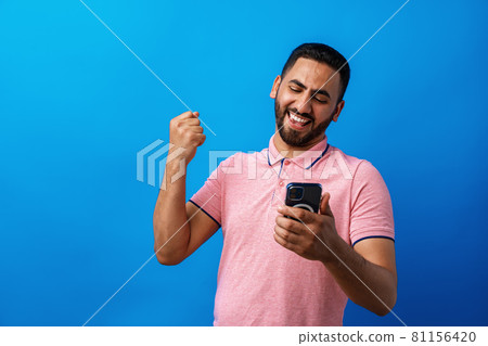 Portrait of arab man using his smartphone in studio 81156420