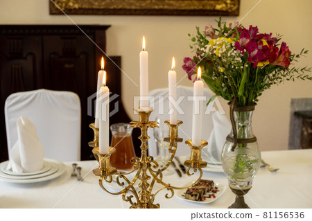 Served banquet restaurant table with candelabrum candles, glasses, napkins and flower vase, selective focus 81156536