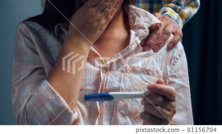 woman with pregnancy test. The man stays behind tense wife 81156704