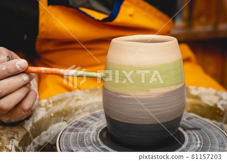 Potter working on potters wheel with clay. Potter working on potters wheel with clay. 81157203